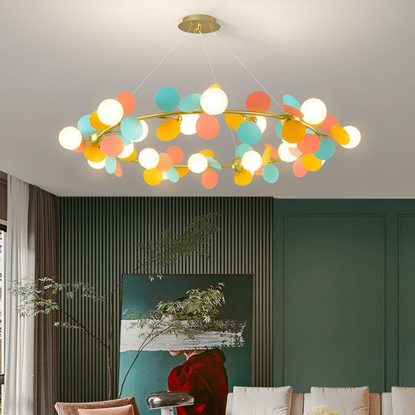 Une image d'un lustre rond avec des boules en verre colorées. Le lustre est suspendu au plafond et il y a un mur vert avec un tableau et un canapé en dessous. NI-3359220986,NI-6740650284,NI-1383698465,NI-7349974205,NI-5465303557,NI-8326850780,NI-0431567387,NI-7145367955,NI-2291394800,NI-7147291565,NI-8291187134,NI-0131623052,