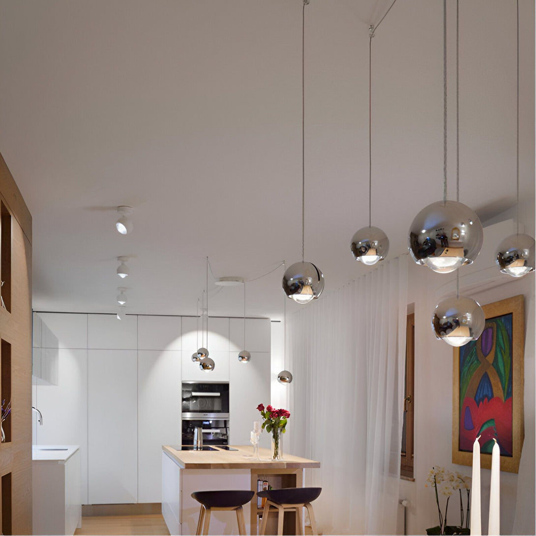 Une image d'une cuisine moderne avec des suspensions en métal chromé et une table à manger en bois avec des chaises hautes. OB-1416333185,OB-1568639201,OB-983265761X,OB-4434955144,OB-3129829164,OB-0998241695,OB-6069405625,OB-5906347348,OB-9038855125,OB-7633987596,OB-8882831361,OB-4666004629,