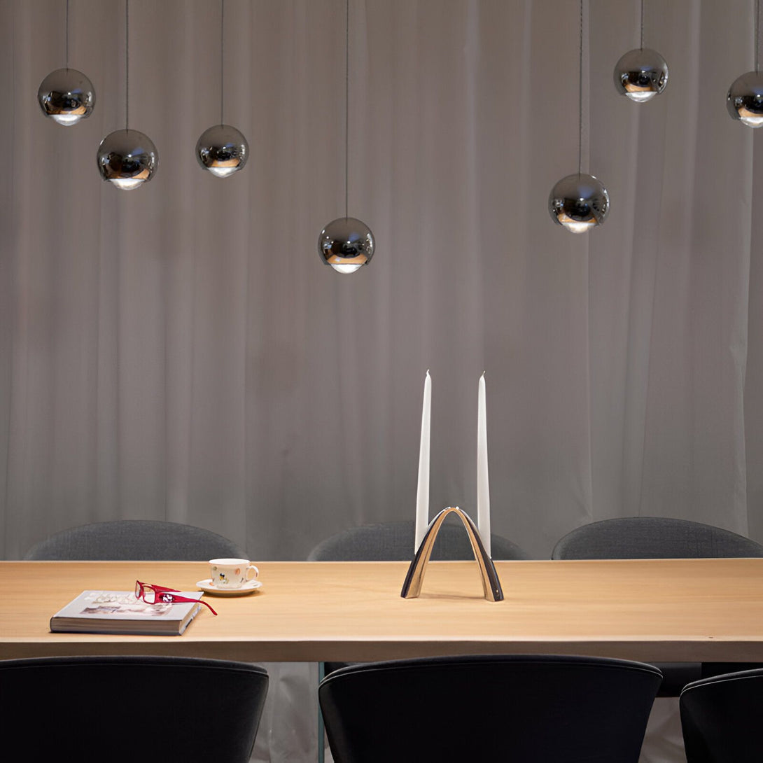 Une table à manger en bois avec des chaises noires et des suspensions lumineuses en forme de boules en métal. OB-1416333185,OB-1568639201,OB-983265761X,OB-4434955144,OB-3129829164,OB-0998241695,OB-6069405625,OB-5906347348,OB-9038855125,OB-7633987596,OB-8882831361,OB-4666004629,