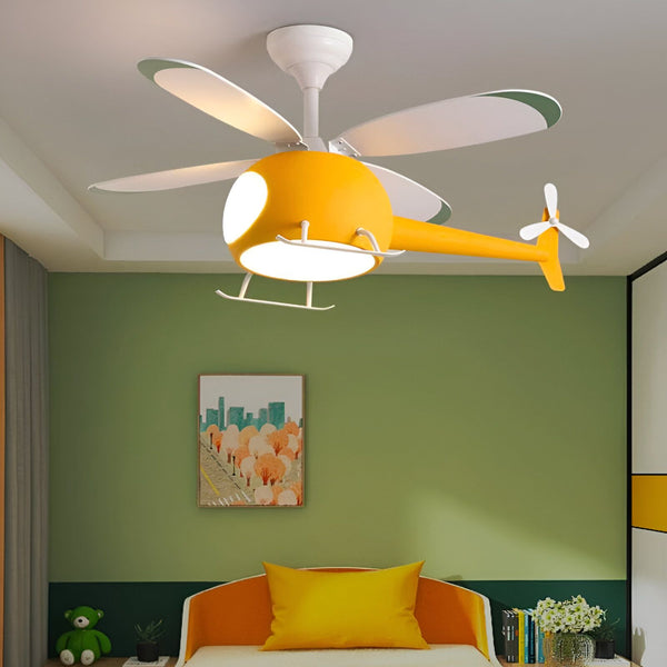 Un ventilateur de plafond jaune en forme d'hélicoptère est suspendu au plafond d'une chambre d'enfant. Les murs sont peints en vert et le sol est recouvert de moquette beige. Il y a un lit, une armoire et un bureau dans la chambre. PL-8693935798,PL-353767788X,PL-1263651992,PL-7509279054,PL-0416610994,PL-066763049X,