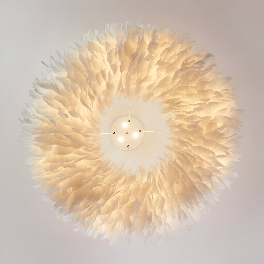 L'image montre un luminaire rond et blanc composé de plumes d'autruche. Il est suspendu au plafond et diffuse une lumière douce et tamisée.