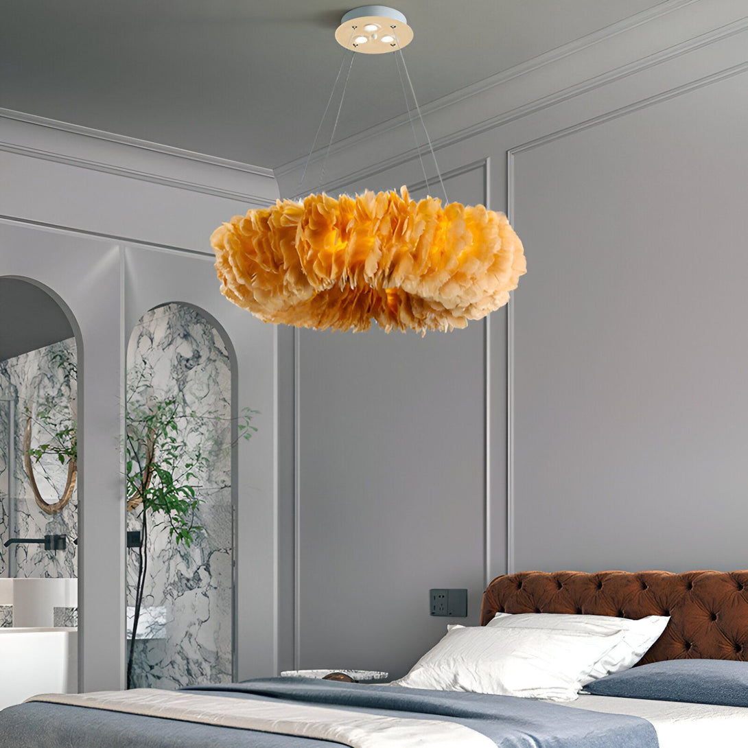 Une image d'un lustre en plumes d'autruche jaune. Le lustre est rond et est suspendu au plafond. Il y a un lit en dessous du lustre. Le lit est recouvert d'une couette et d'oreillers blancs. Il y a une plante verte à côté du lit.
