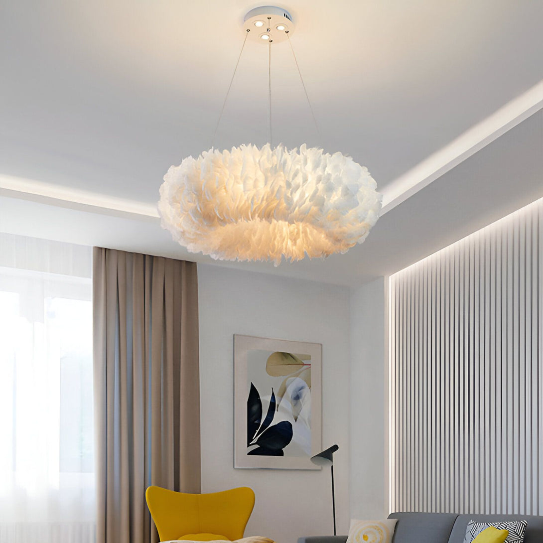 Une image d'un lustre en plumes blanches. Le lustre est rond et a un diamètre d'environ 80 cm. Il est suspendu au plafond par trois câbles métalliques. Le lustre est éclairé par une ampoule LED blanche. La lumière est douce et diffuse. Le lustre est placé dans un salon. Il y a un canapé gris, une table basse et un tapis. Le sol est en parquet. Les murs sont blancs.