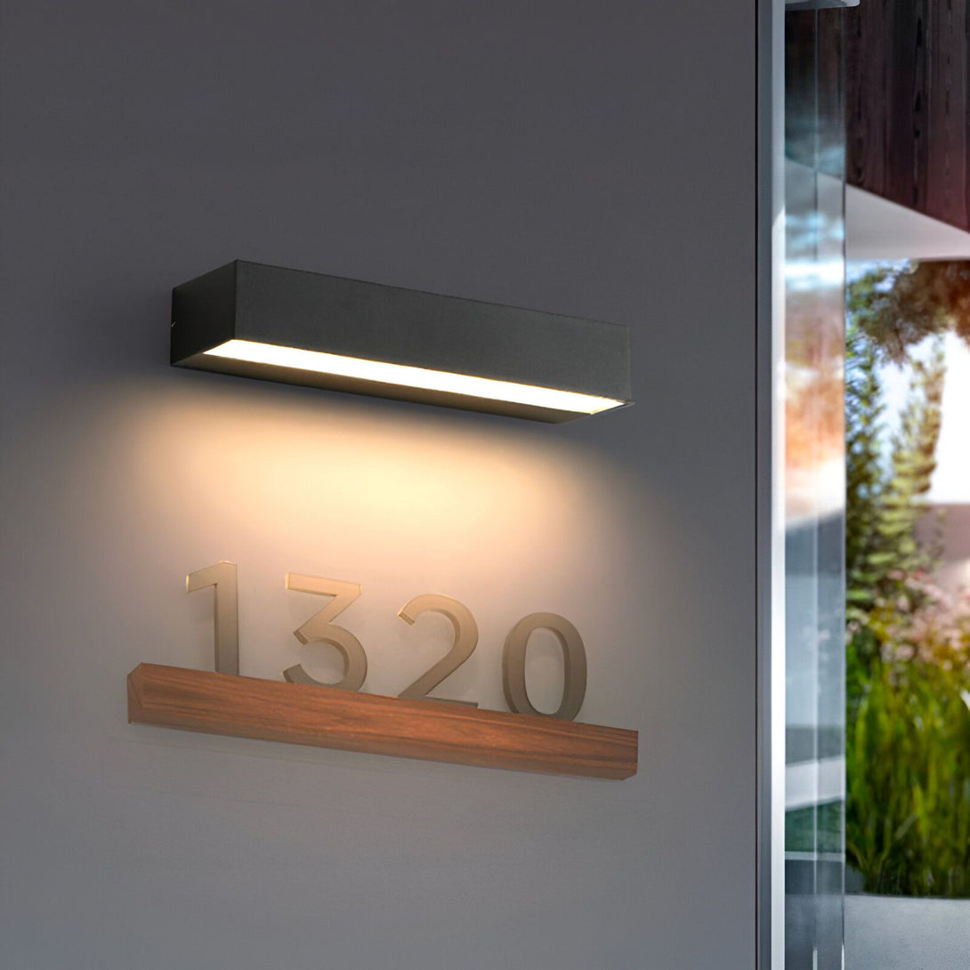 Une applique murale noire avec une lumière blanche qui éclaire un numéro de maison en bois flottant. NA-033735863X,NA-9496728251,NA-8762483625,NA-6848322024,NA-1955103321,NA-7992054555,NA-9701687752,NA-4955698107,