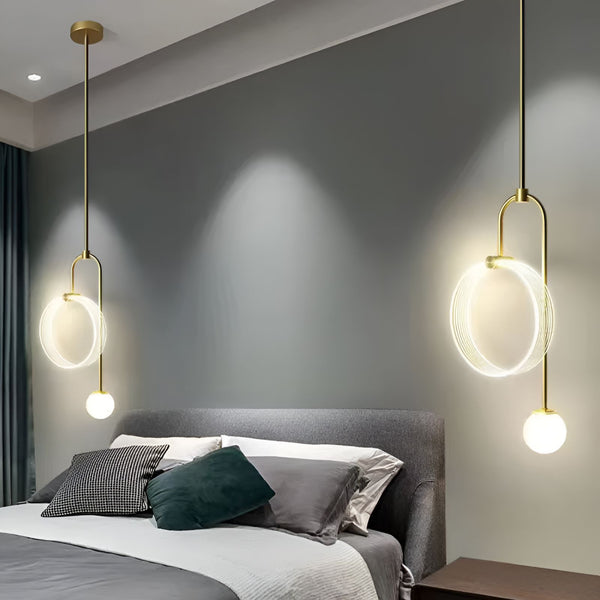 Une paire de lampes suspendues modernes avec des abat-jours en verre soufflé. Les lampes sont suspendues à des câbles noirs et ont des finitions en laiton. RI-3984858582,RI-6157124075,RI-3861898691,RI-4719001157,