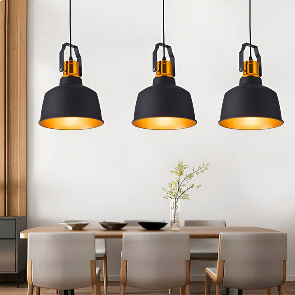 Une image de trois suspensions en aluminium de couleur noire avec une ampoule dorée à l'intérieur. Les suspensions sont accrochées au plafond par un fil noir et sont disposées au-dessus d'une table à manger en bois avec des chaises noires. SO-6437109300,SO-7477021855,
