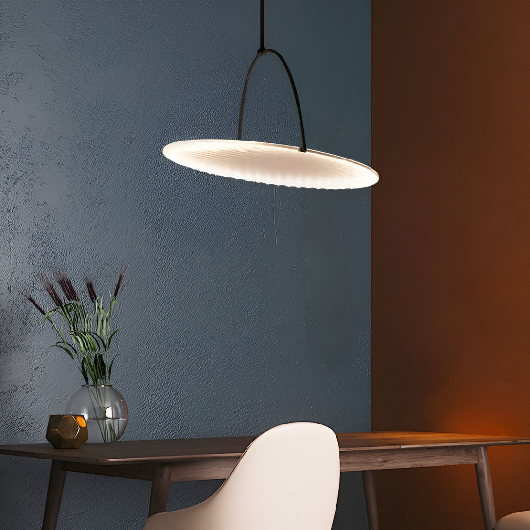 Une image d'une lampe suspendue au-dessus d'une table à manger. La lampe est ronde et blanche, et la table est en bois. Il y a une chaise blanche à côté de la table. Le mur du fond est bleu foncé et le mur de droite est marron. CO-2700004558,CO-8923300365,