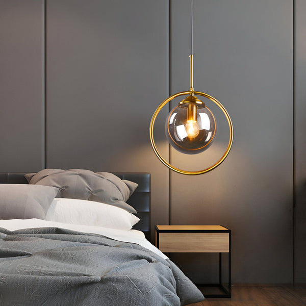 Une lampe suspendue en verre avec une monture en métal doré. La lampe est de forme ronde et émet une lumière chaude et diffuse. Elle est idéale pour éclairer une pièce à vivre ou une chambre à coucher. VE-8794649839,VE-2128730597,VE-1613731329,VE-1755348045,VE-9817635031,VE-7370967131,