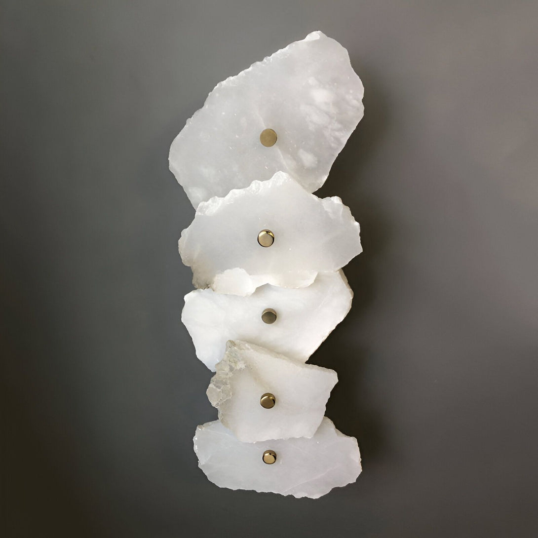Une applique murale en albâtre blanc. L'applique est composée de cinq plaques d'albâtre de forme organique, fixées au mur par des rivets en laiton. La lumière est diffusée à travers l'albâtre, créant une ambiance douce et chaleureuse. SO-7123178807,SO-3400845779,SO-5887625120,SO-4903500098,SO-3636295578,SO-849075828X,SO-146225764X,SO-9847436983,SO-5004486255,SO-7723655282,SO-1193799546,SO-1571209999,SO-7257596271,SO-0868806838,SO-4134838452,SO-3316489436,SO-2323713949,SO-5166243994,