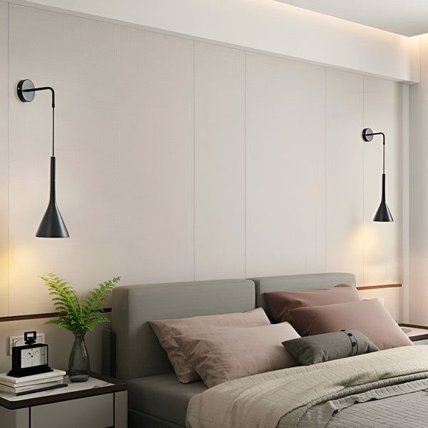 Une paire d'appliques murales LED noires en forme de trompette. Les appliques sont fixées au mur au-dessus d'un lit. UL-5012393805,UL-1789531950,UL-7329016853,UL-3035215383,UL-0292922604,UL-0840736878,UL-3185745663,UL-3751450505,UL-4053481821,
