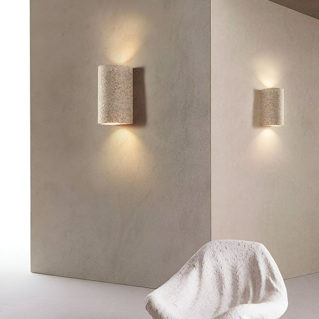 Une image de deux appliques murales en plâtre. Les appliques sont de forme cylindrique et émettent une lumière douce. NA-3923317158,NA-6067964244,NA-3358865746,NA-2876745291,NA-6391241465,