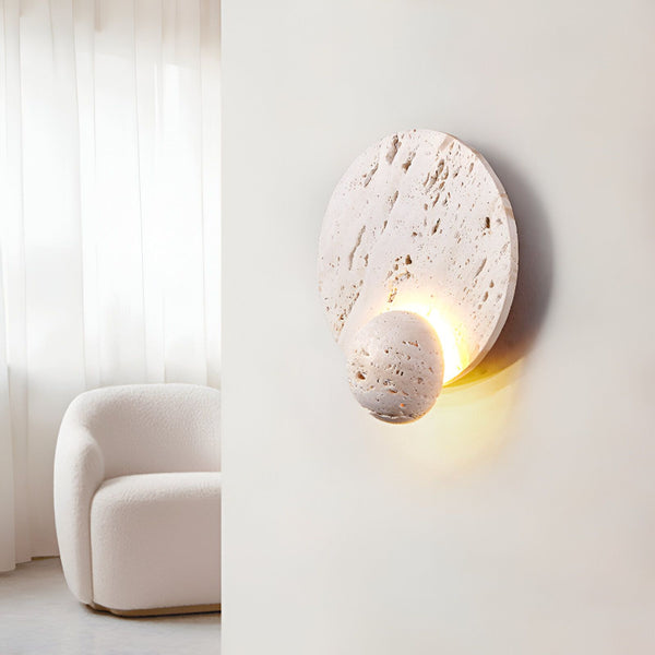 Une applique murale en pierre avec une forme ronde et une lumière LED intégrée. L'applique est fixée au mur et diffuse une lumière douce et chaude. PI-3050710888,