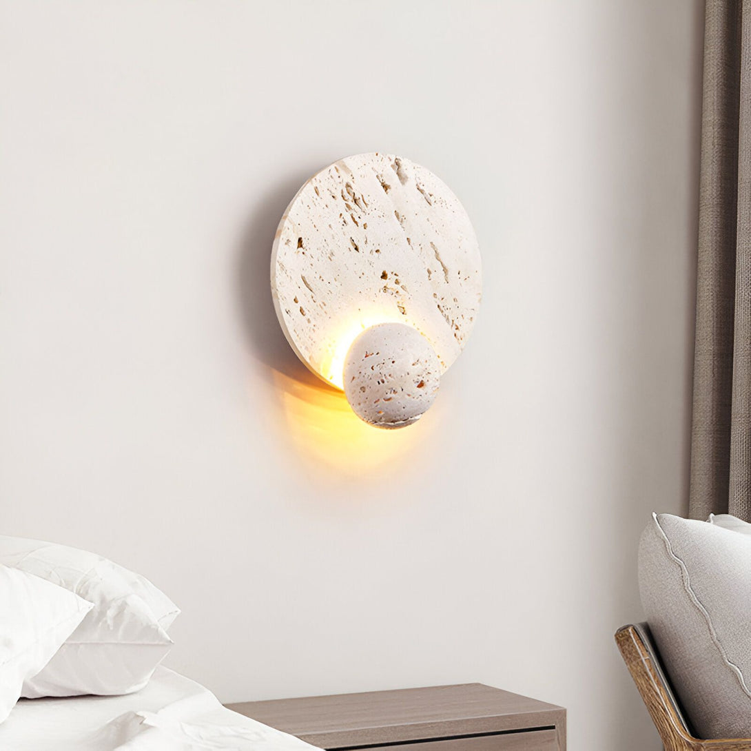 Une applique murale en pierre avec une forme ronde et une lumière chaude. PI-3050710888,
