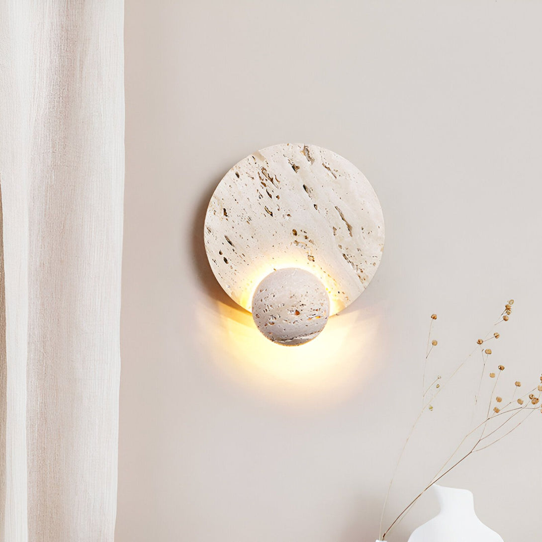 Une applique murale en pierre avec une forme ronde et une lumière chaude. PI-3050710888,