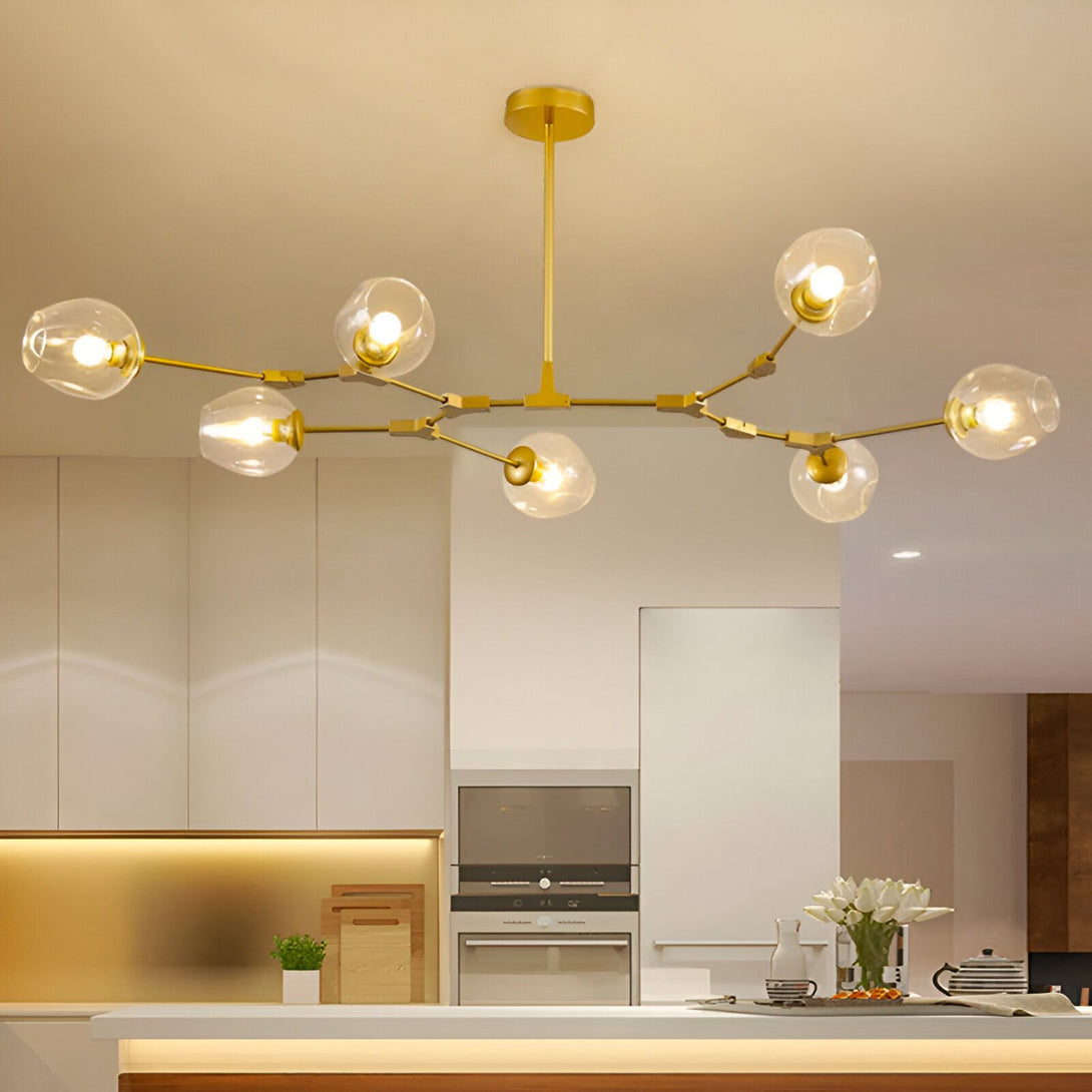 Une image d'un lustre doré à six branches avec des globes en verre transparent. Le lustre est suspendu au plafond et éclaire la pièce.