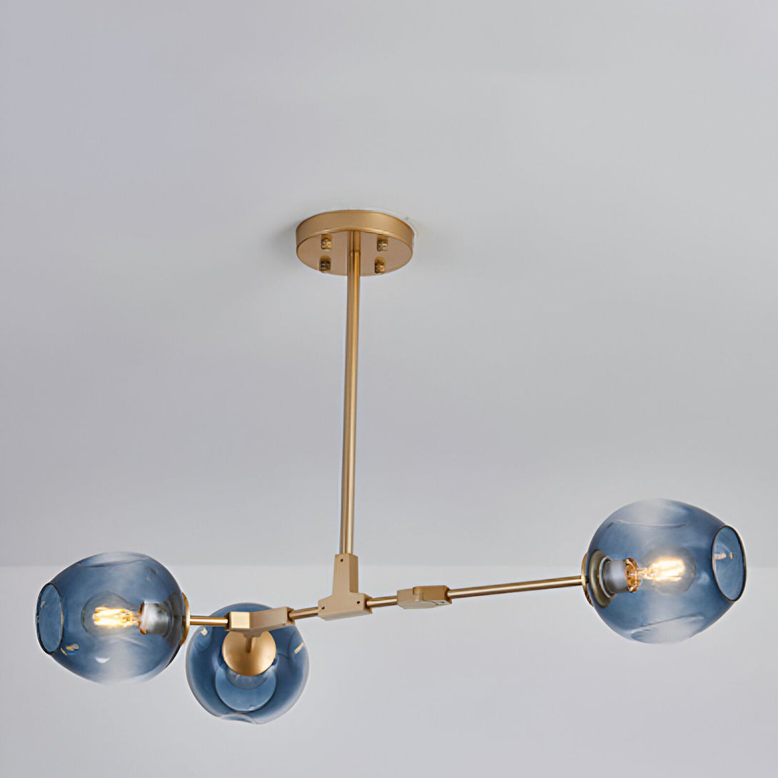 Une image d'un plafonnier doré à trois branches avec des globes en verre bleu.