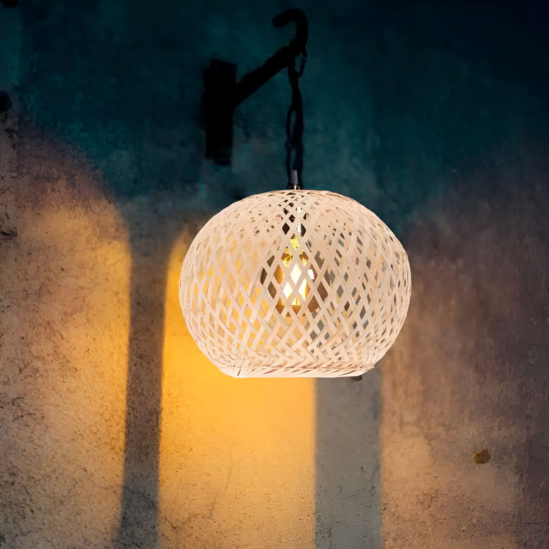 Une lampe en osier suspendue au plafond diffuse une lumière tamisée. PA-6497010653,