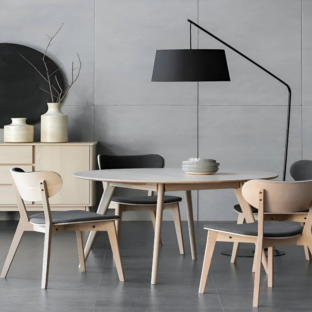 Une table à manger ronde en bois avec quatre chaises et une lampe sur pied noire. DE-0903639068,DE-7087444387,