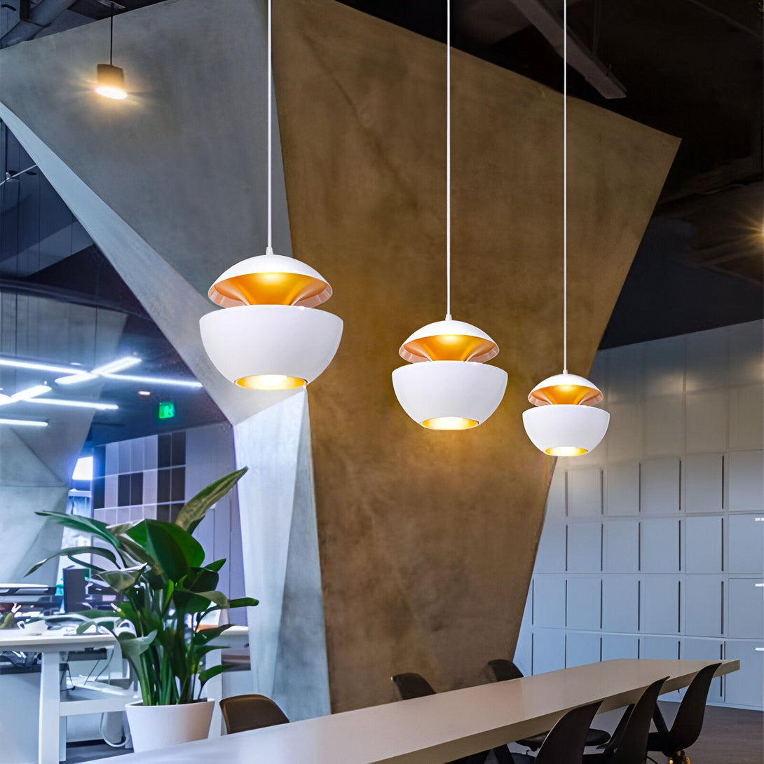 Une image de trois suspensions Luminaire Suspension Blanche. Les suspensions sont de couleur blanche et ont une forme de demi-sphère. Elles sont suspendues à des fils blancs et sont éclairées par des ampoules dorées. Les suspensions sont installées dans un intérieur moderne avec un mur en béton et un sol en bois. WI-6650996920,WI-5835788258,