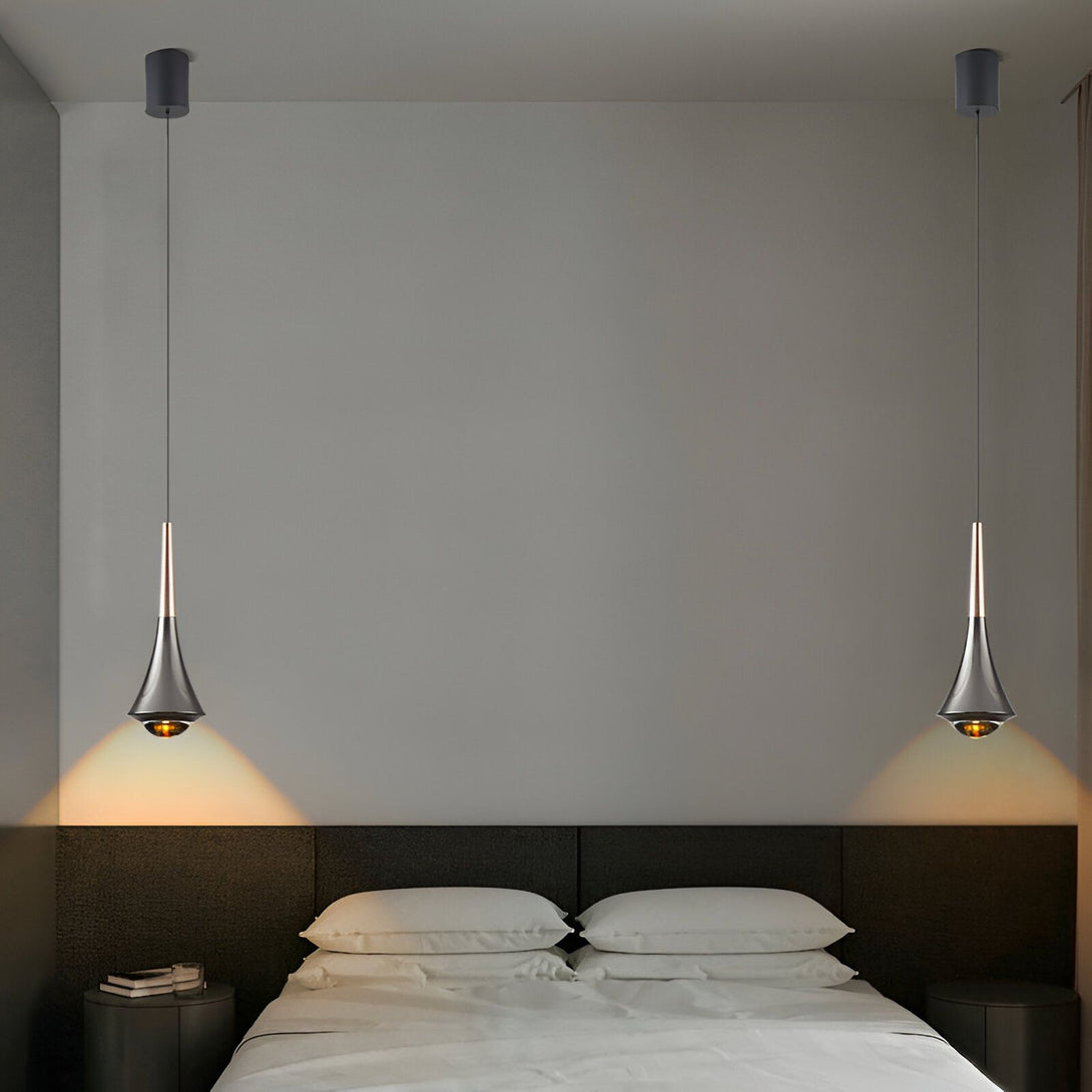 Une paire de lampes suspendues modernes en forme de trompette avec une finition noire et dorée. Les lampes sont suspendues au plafond par un fil noir et sont dotées d'un abat-jour en forme de trompette qui diffuse une lumière chaude et tamisée. Les lampes sont parfaites pour une utilisation dans une chambre à coucher, un salon ou une salle à manger.