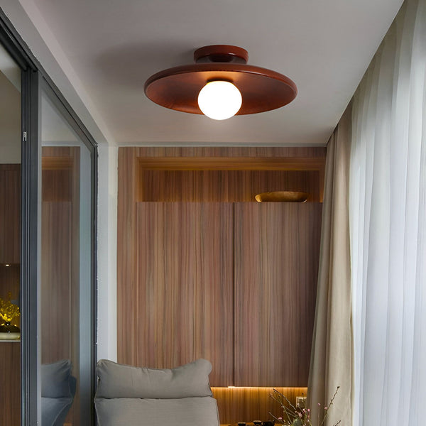 Une lampe suspension en bois avec une forme de soucoupe volante. La lampe est suspendue au plafond par un fil noir. La lampe est en bois de couleur marron foncé et a une forme ronde. La lampe est munie d'une ampoule blanche. VE-009075851X,VE-9101570242,VE-2924184185,VE-0274696150,