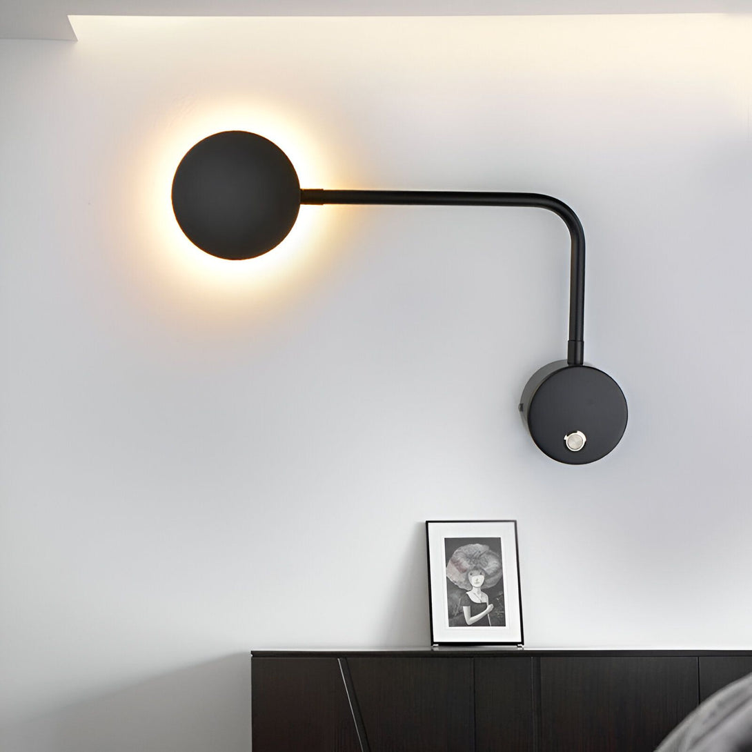 Une image d'un lampadaire noir avec un abat-jour rond et un bras articulé. Il est fixé au mur et émet une lumière chaude. À côté, il y a un cadre photo sur une commode noire. TE-9932666998,TE-0497144689,TE-7038265067,TE-3234223823,TE-3324282896,TE-3076707841,