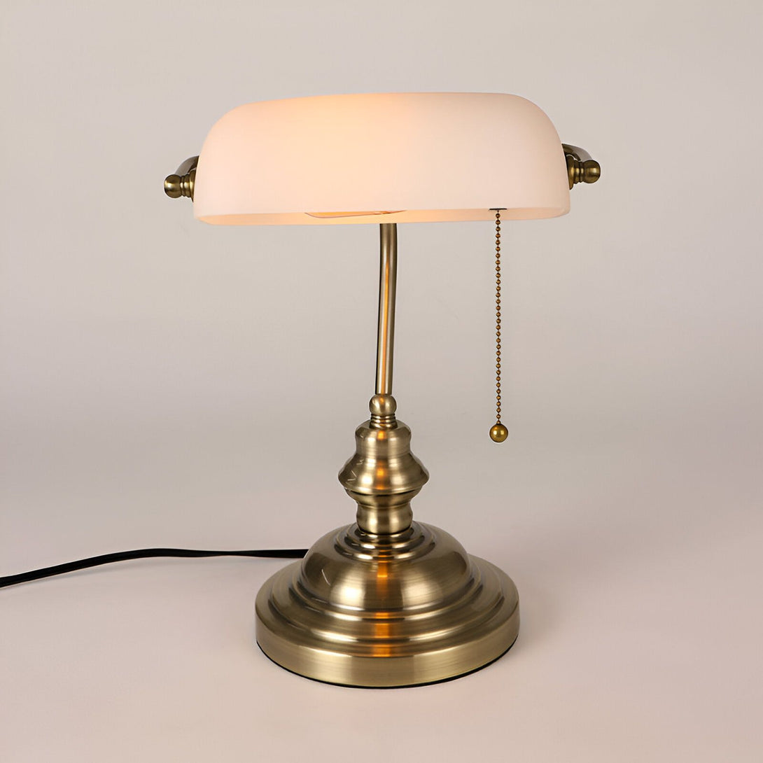 Une lampe de bureau vintage avec un abat-jour en verre opalin et une base en métal. La lampe est de couleur bronze et possède un cordon d'alimentation avec un interrupteur à tirette. Elle mesure 40 cm de haut et 25 cm de large. VI-6000882076,VI-6355337148,VI-411590576X,VI-8627305870,