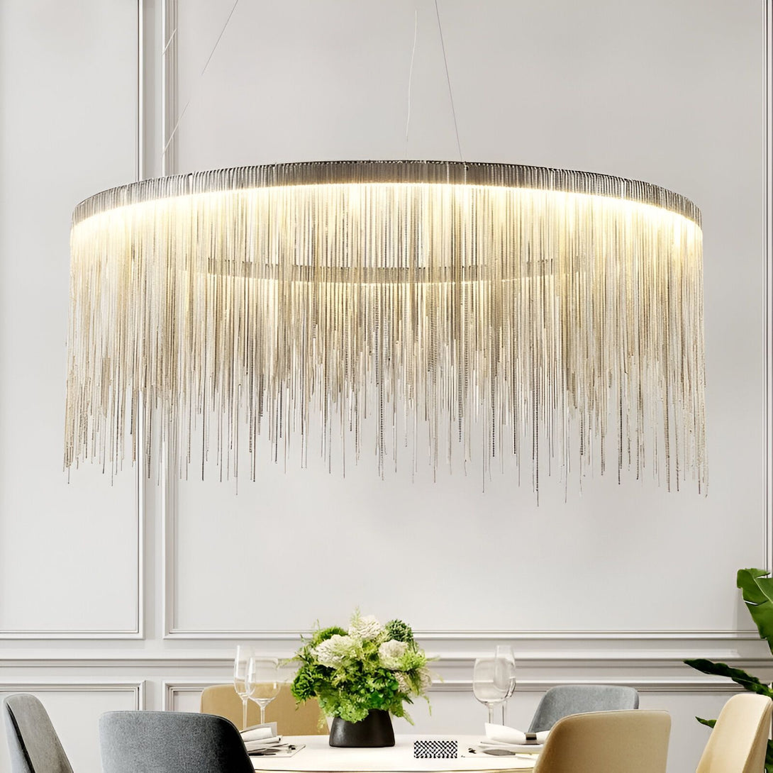 Lustre en acier brossé et aluminium. Ce lustre est de forme ronde et est suspendu au plafond par une chaîne. Il est composé de plusieurs rangées de fines chaînes en acier brossé et d'aluminium qui créent un effet de cascade de lumière. Ce lustre est idéal pour les pièces à vivre, les salles à manger et les chambres à coucher. VA-9669156378,VA-3706166739,VA-0973338423,