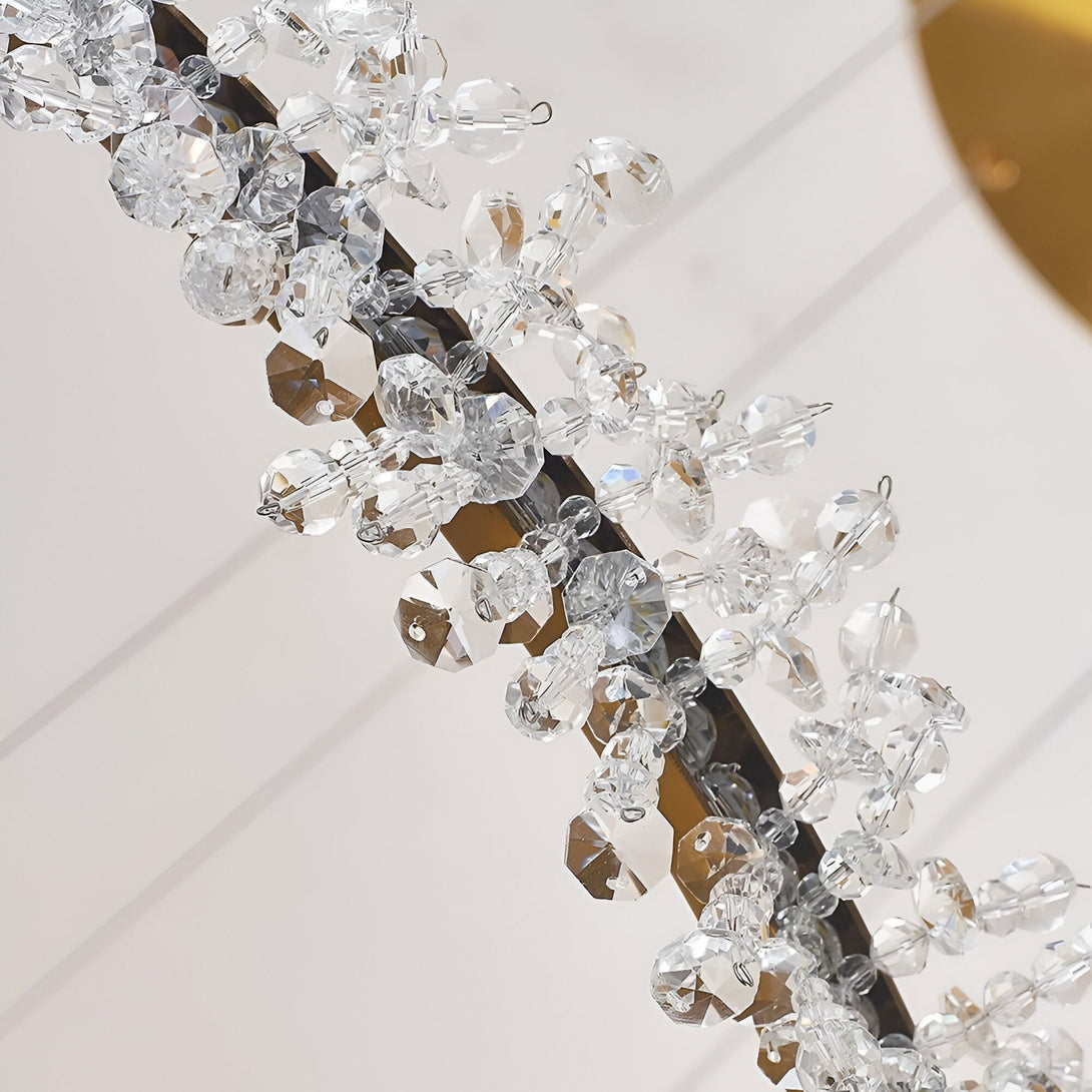 Une image en gros plan d'un lustre en cristal avec des perles de cristal transparentes et des pampilles en cristal. Le lustre est suspendu à un cadre en métal doré. MA-9813802618,MA-5171703868,MA-1967552312,