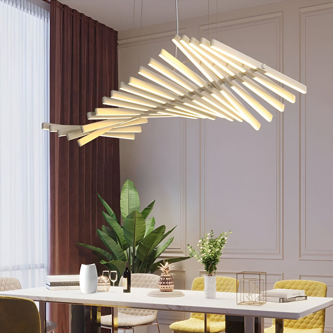 Une image d'un lustre moderne suspendu au plafond. Le lustre est composé de plusieurs tubes LED blancs qui s'entrecroisent. Il est suspendu au plafond par des câbles métalliques fins. La pièce est décorée dans un style moderne avec des murs blancs et des meubles blancs. NI-638404028X,NI-3392886920,NI-3594454118,NI-2267460866,