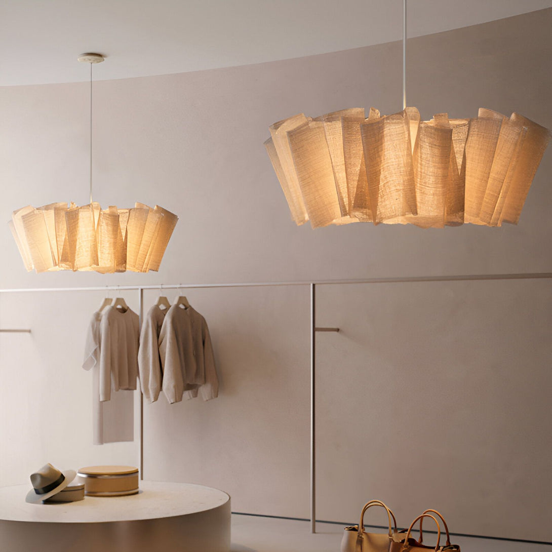 Une image de deux lampes en tissu beige suspendues au plafond d'un magasin. Les lampes sont de forme ronde et ont des plis. Il y a des vêtements sur des cintres au mur derrière les lampes. Il y a un chapeau sur une table ronde devant les lampes. Il y a des sacs à main sur le sol devant la table. CA-2898272442,CA-439891451X,CA-9452050160,CA-2079220012,CA-590871531X,CA-0576736929,CA-7708015111,CA-9291669369,CA-4924250511,CA-3510433556,CA-4748290552,CA-0662280849,