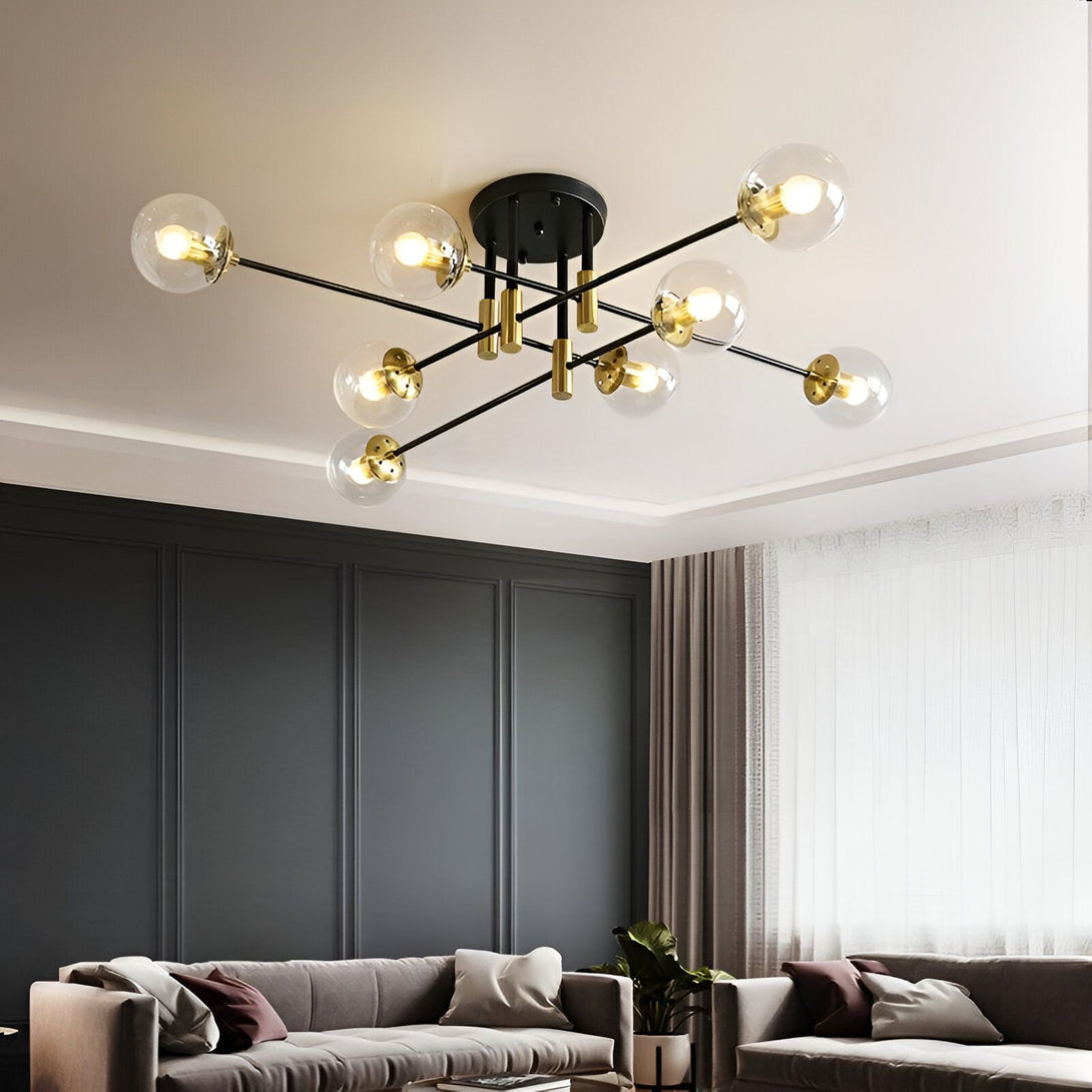 Un lustre moderne avec des boules en verre transparent et des branches en métal noir. Il est suspendu au plafond et éclaire le salon. NE-5806650421,NE-7799522623,NE-7437635623,NE-2735111245,