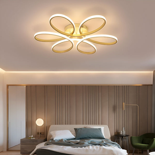 Une image d'un plafonnier LED en forme de fleur. Le plafonnier est de couleur or et blanc et est composé de cinq anneaux. Il est suspendu au plafond et éclaire la pièce. FL-356354848X,FL-5370961972,FL-9168897952,