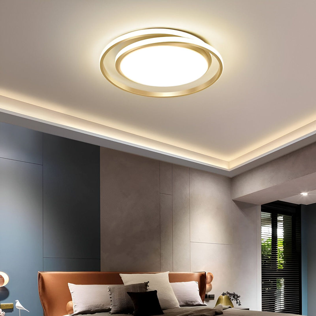 Un plafonnier LED doré de forme ronde est fixé au plafond. Il est composé de deux cercles, l'un à l'intérieur de l'autre. Le cercle intérieur est plus petit que le cercle extérieur. Le plafonnier est allumé et diffuse une lumière blanche et brillante. AN-5533071989,AN-6442358399,AN-1091116326,