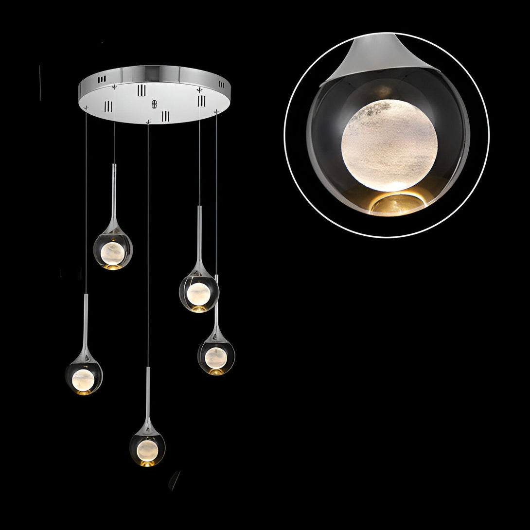 Une image d'un lustre moderne avec cinq boules en verre soufflé. Les boules sont de couleur ambre et ont une forme de goutte. Le lustre est suspendu au plafond par un fil de métal argenté. IN-6570546732,IN-0202242234,IN-9460160360,IN-5087841252,IN-4331503488,IN-9491831844,