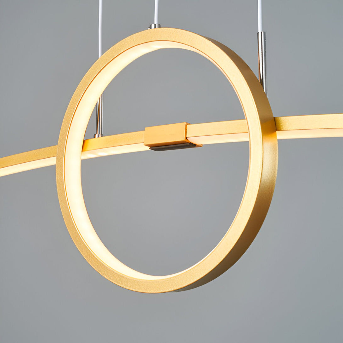 Une image d'une suspension LED ronde et dorée. La suspension est composée de deux anneaux, l'un à l'intérieur de l'autre. L'anneau extérieur est plus grand que l'anneau intérieur. Les deux anneaux sont reliés par une barre horizontale. La suspension est suspendue par deux câbles fins. LO-6297965579,LO-5510735155,