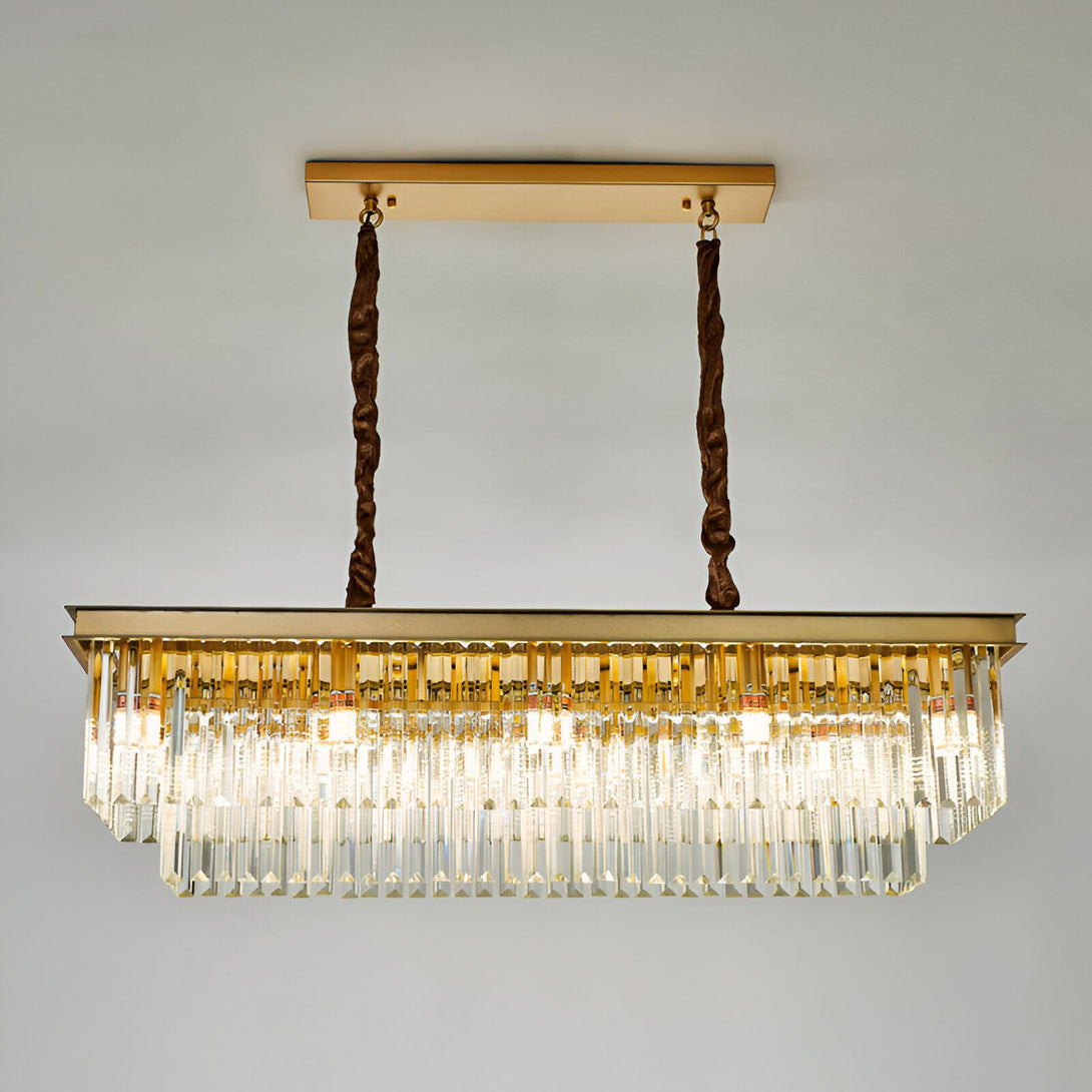 Une image d'un lustre en cristal doré à LED de forme rectangulaire. Il est suspendu au plafond par deux câbles torsadés marron. Le lustre est composé de plusieurs rangées de pampilles de cristal transparentes et de baguettes en cristal doré. LO-8531375401,LO-5736785838,LO-1500856088,LO-5736656043,