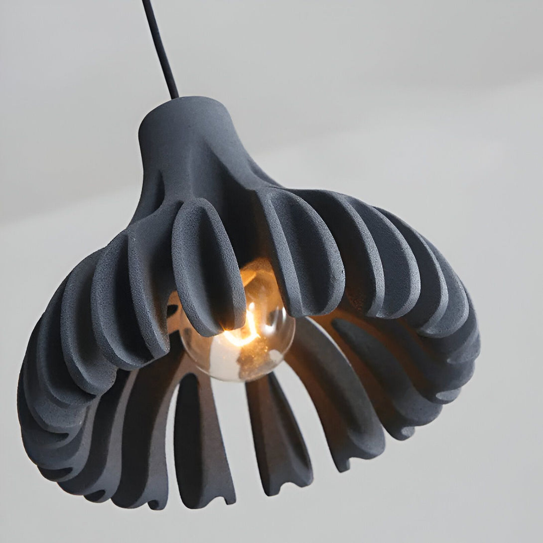 Une lampe en céramique noire en forme de fleur est suspendue au plafond. DE-4324659125,DE-5800057117,DE-4150070571,DE-3233219504,DE-9759604302,DE-3279579503,DE-8693617931,DE-1599245205,DE-3565828951,DE-8342919889,