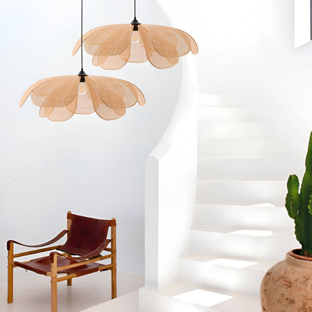 Deux suspensions en forme de fleur en osier beige sont accrochées au plafond. Un fauteuil en cuir marron est placé en dessous. Un escalier en béton blanc est à côté. LI-8878220833,LI-3445087393,LI-1740765222,