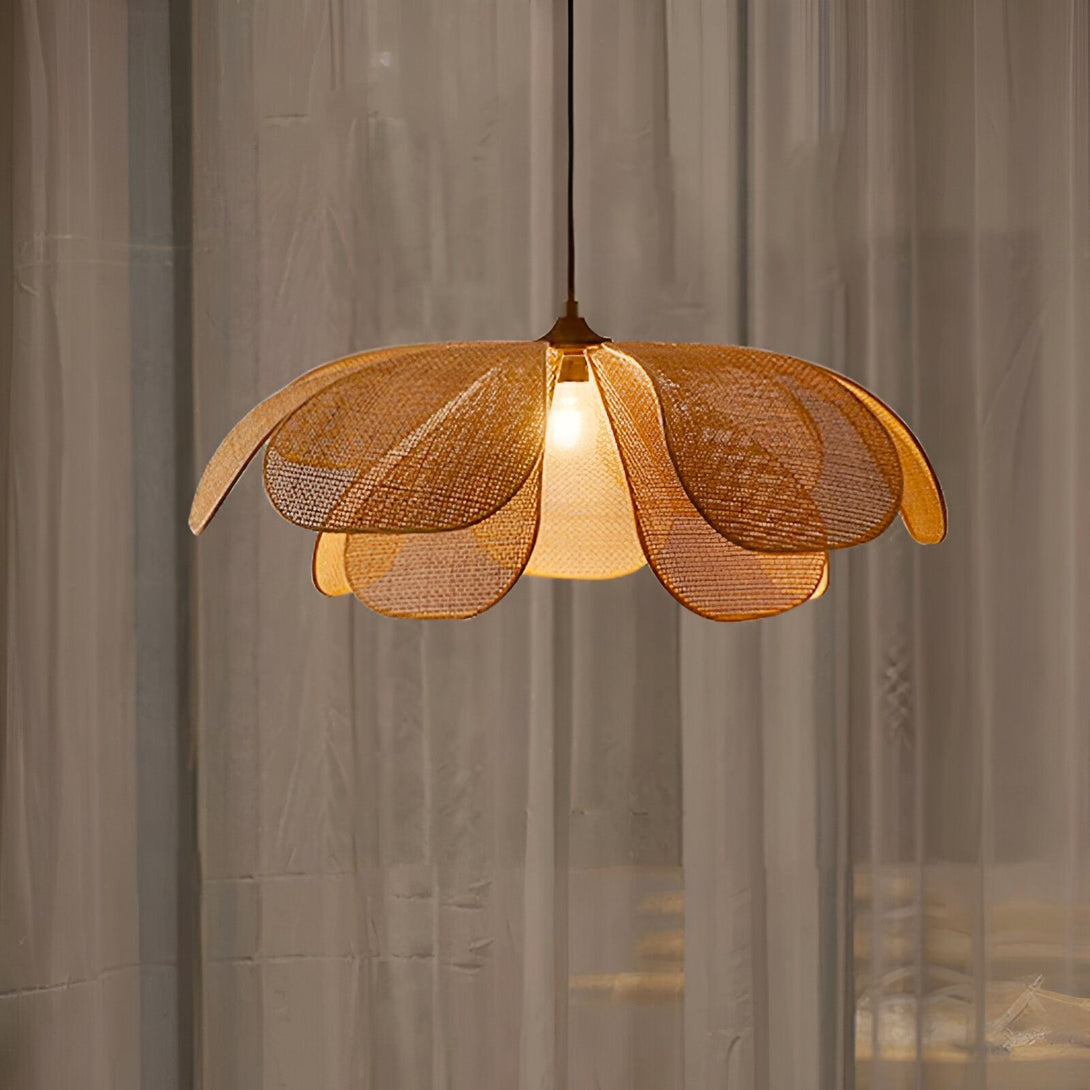 Une lampe en osier en forme de fleur est suspendue au plafond. La lampe est allumée et diffuse une lumière douce et tamisée. LI-8878220833,LI-3445087393,LI-1740765222,