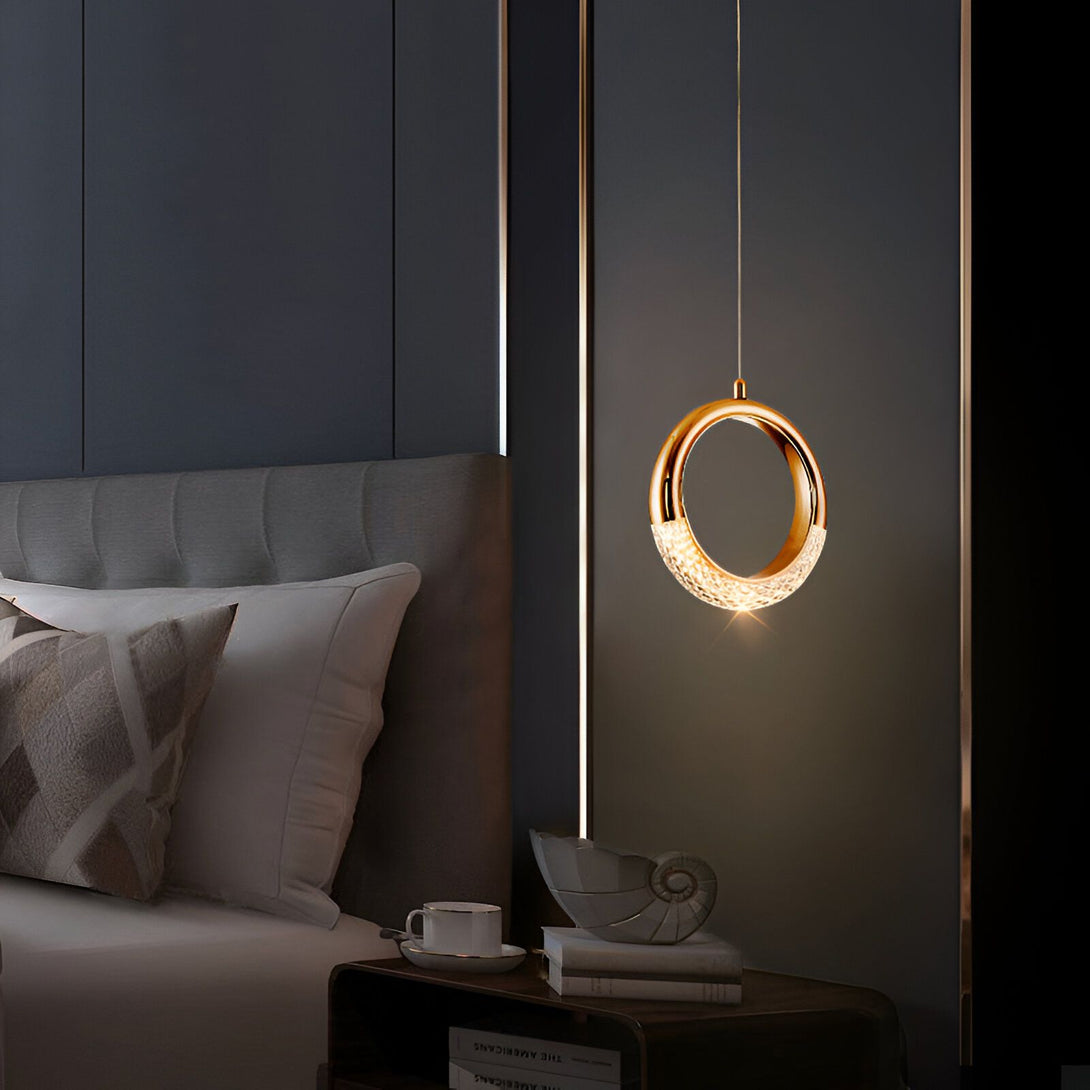 Une image d'une suspension en cristal avec une finition dorée. La suspension est en forme d'anneau et est suspendue par un fil doré. Elle est éclairée par une lumière LED blanche. DI-9163803569,DI-0035455918,DI-9503015359,DI-2507318104,