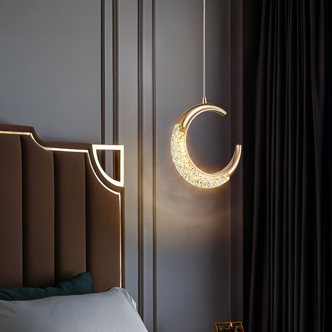 Une suspension en forme de croissant de lune en métal doré avec des cristaux transparents. La suspension est éclairée par une lumière chaude. DI-9163803569,DI-0035455918,DI-9503015359,DI-2507318104,