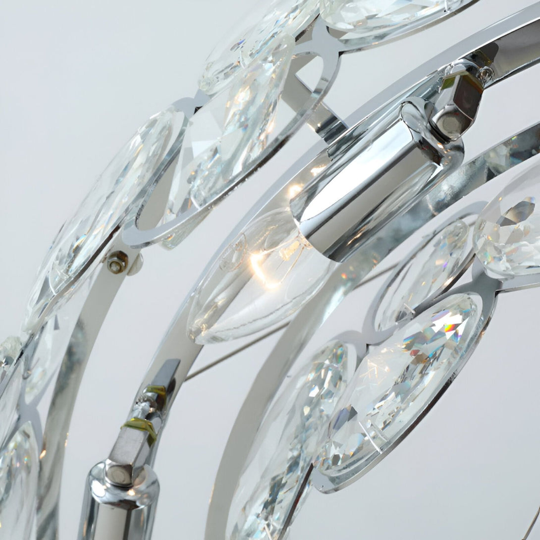 Un lustre en cristal avec des pampilles en forme de feuilles. Le lustre est de couleur argentée et les pampilles sont transparentes. PE-3049239069,PE-966204308X,PE-4267310149,