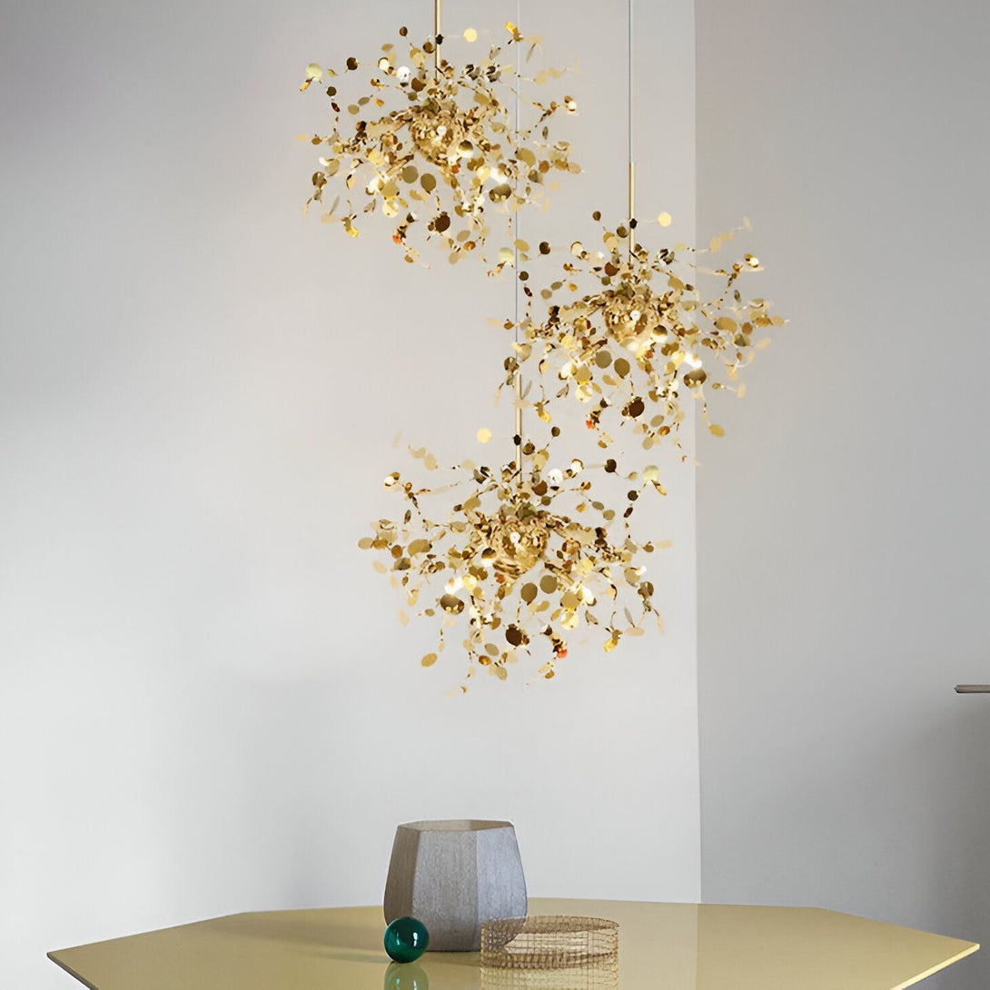 Suspension luminaire en acier doré. Le luminaire est composé de plusieurs branches, chacune étant recouverte de petites feuilles métalliques dorées. Les branches sont disposées de manière à former une sphère. Le luminaire est suspendu au plafond par un câble en acier. SA-8998942399,