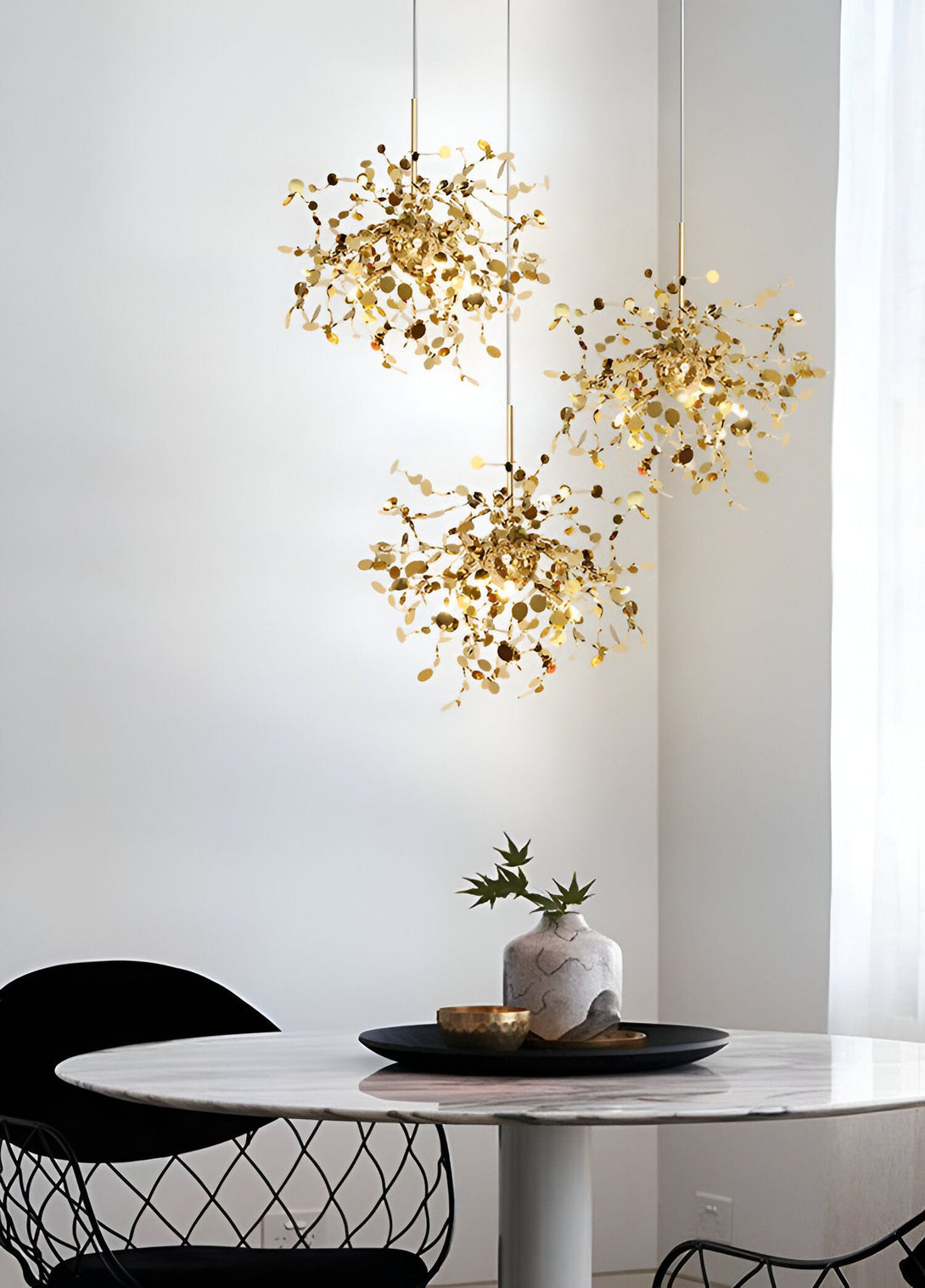 Suspension luminaire en acier inoxydable doré. Cette suspension design est composée de plusieurs branches en acier inoxydable doré qui s'entrecroisent pour former une structure aérienne et légère. Les branches sont agrémentées de feuilles en acier inoxydable doré qui reflètent la lumière et créent ainsi un jeu d'ombres et de lumières. Cette suspension luminaire est idéale pour éclairer un salon, une salle à manger ou une cuisine. SA-8998942399,