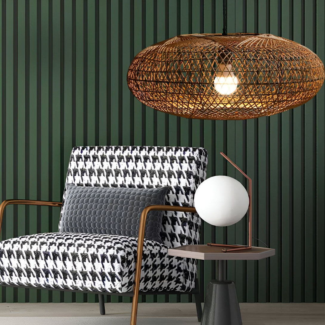 Une image d'un salon avec un fauteuil à motifs noir et blanc, une table d'appoint avec une lampe blanche et un grand luminaire en osier au plafond. DE-8351322709,