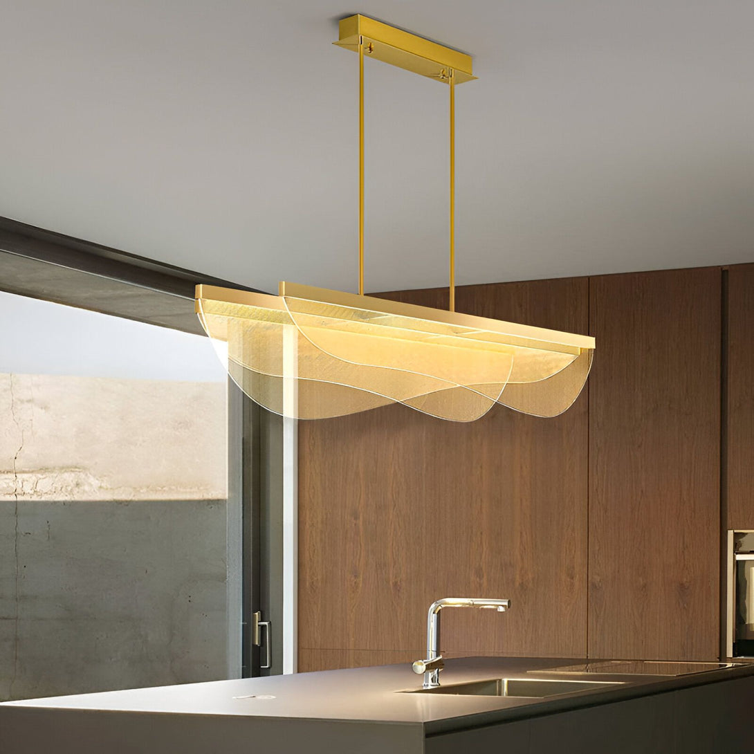 Une suspension rectangulaire en métal doré avec des diffuseurs en verre ondulé transparent. IT-8844876027,