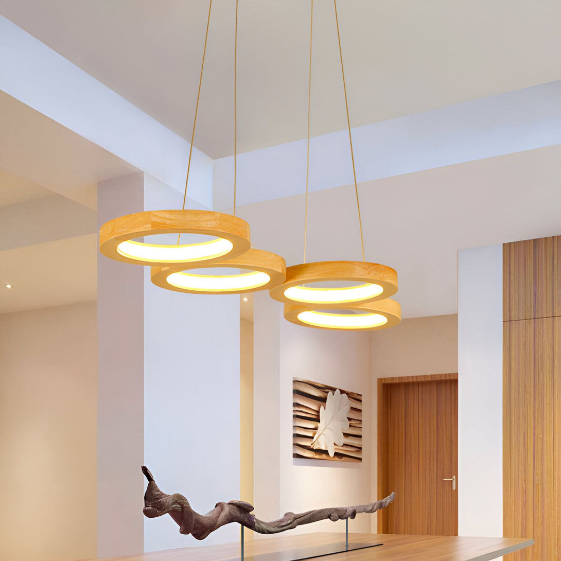 Une image d'un lustre en bois avec trois anneaux. Le lustre est suspendu au plafond par des fils métalliques. Les anneaux sont de différentes tailles et sont disposés de manière à créer un effet de spirale. Le lustre est allumé et émet une lumière chaude et diffuse. EL-1630698474,EL-3714136010,EL-2272764185,EL-0448510413,