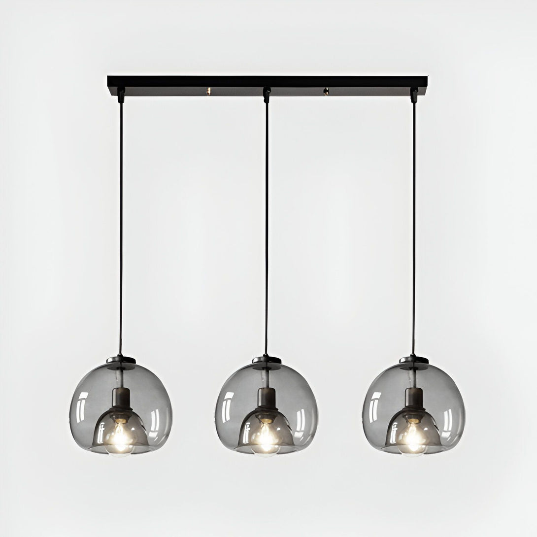 Une image d'une suspension luminaire avec trois globes en verre fumé. La suspension est fixée au plafond par une barre en métal noir. Les globes en verre sont de forme ronde et ont une finition fumée qui donne une lumière tamisée. LO-392800655X,LO-1744084009,LO-6177852890,LO-9368657548,LO-8985353357,LO-3900887128,LO-3975260971,LO-5705639805,LO-0592023001,LO-4438458307,LO-6781505785,LO-039647747X,