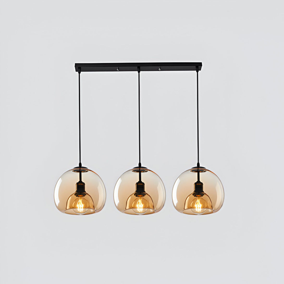 Une image d'une suspension luminaire avec trois globes en verre de couleur ambre. La suspension est fixée au plafond par une barre en métal noir. LO-392800655X,LO-1744084009,LO-6177852890,LO-9368657548,LO-8985353357,LO-3900887128,LO-3975260971,LO-5705639805,LO-0592023001,LO-4438458307,LO-6781505785,LO-039647747X,